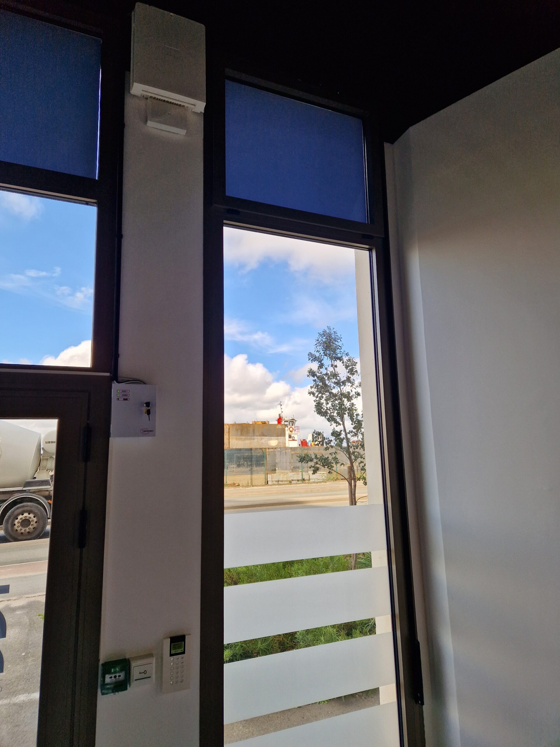 Installation Caméra Sécurité et Maison Intelligente Technicien installant une caméra de sécurité dôme au plafond tout en gérant le système de maison intelligente avec un smartphone affichant un code de verrouillage.