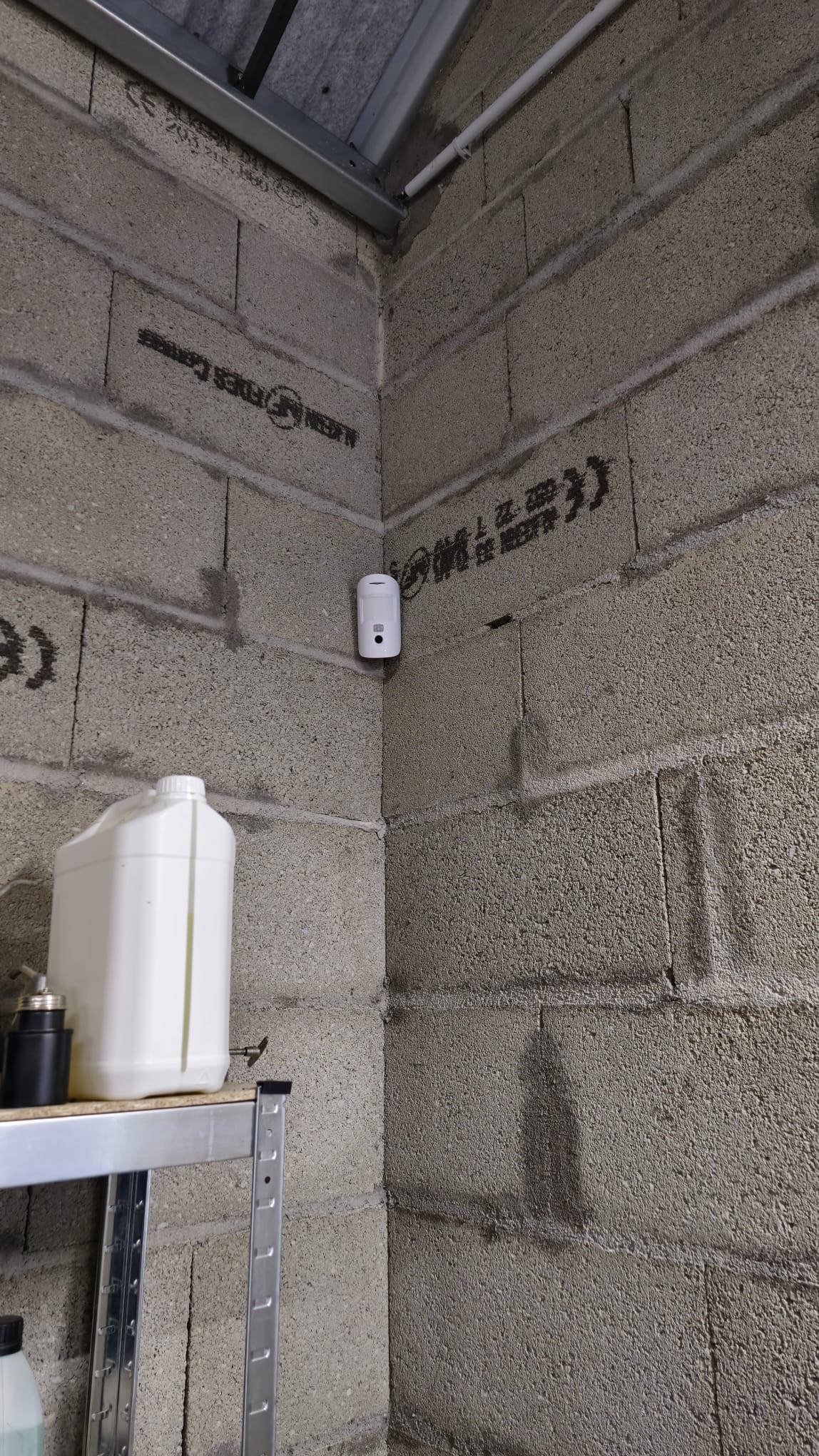 Installation Caméra Sécurité et Maison Intelligente Technicien installant une caméra de sécurité dôme au plafond tout en gérant le système de maison intelligente avec un smartphone affichant un code de verrouillage.