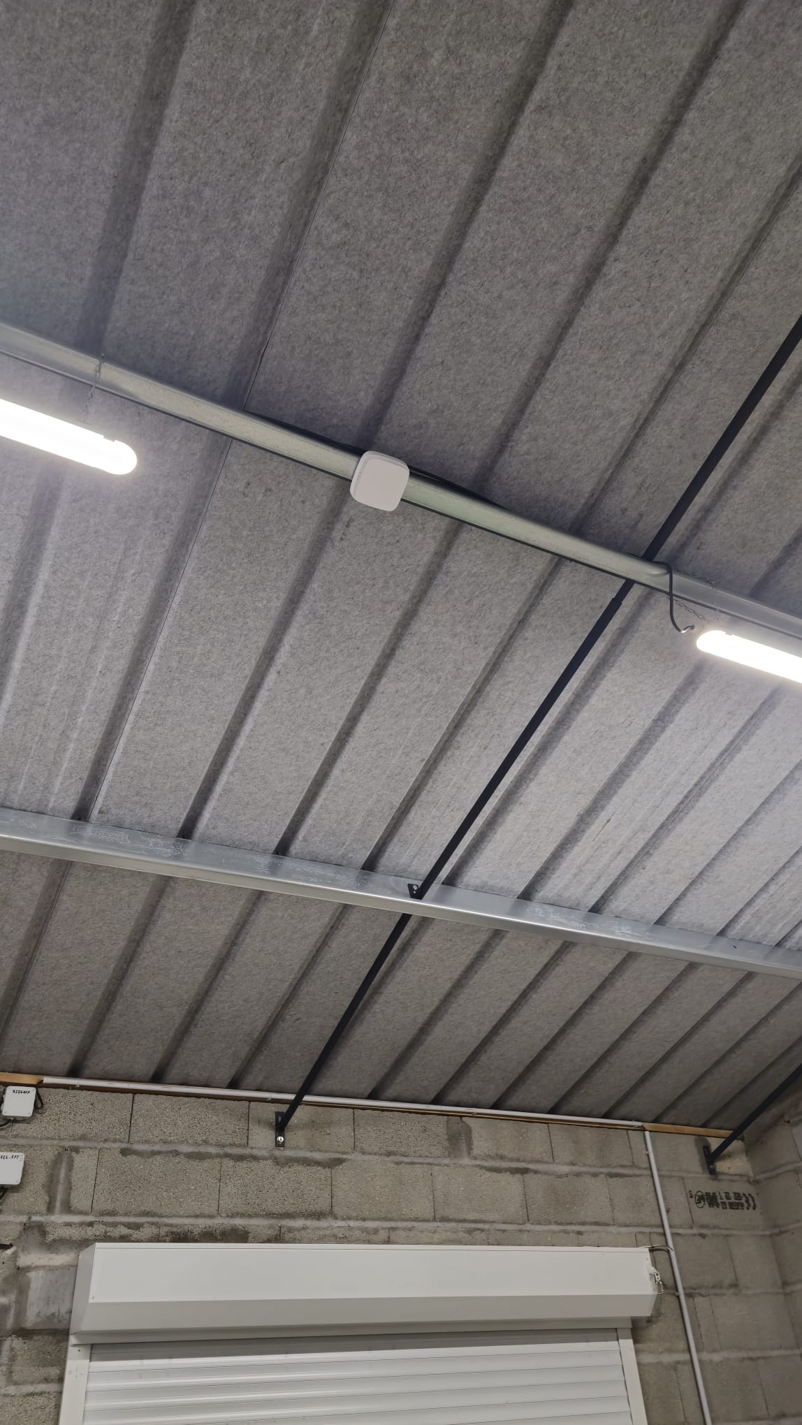 Installation Caméra Sécurité et Maison Intelligente Technicien installant une caméra de sécurité dôme au plafond tout en gérant le système de maison intelligente avec un smartphone affichant un code de verrouillage.