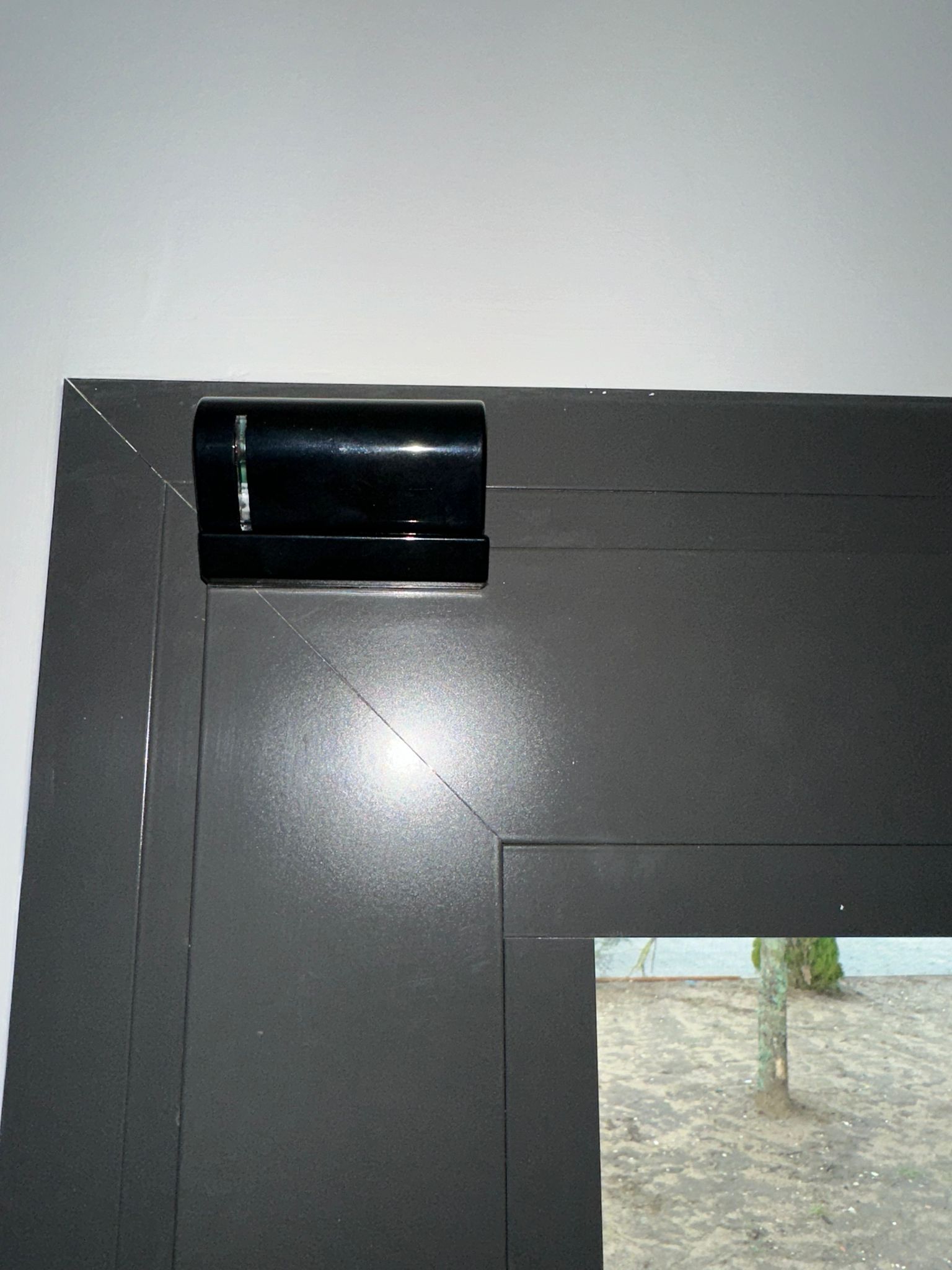 Installation Caméra Sécurité et Maison Intelligente Technicien installant une caméra de sécurité dôme au plafond tout en gérant le système de maison intelligente avec un smartphone affichant un code de verrouillage.