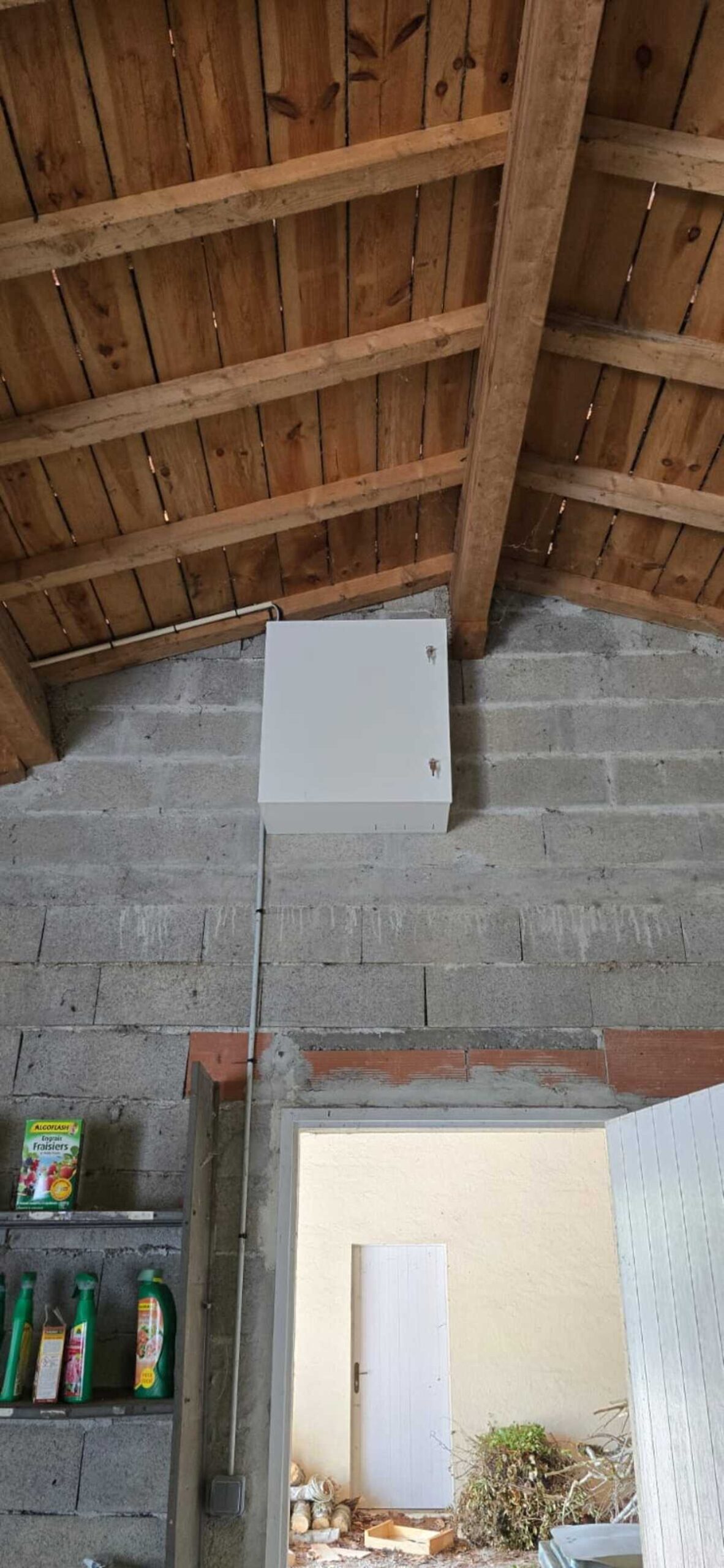 Installation Caméra Sécurité et Maison Intelligente Technicien installant une caméra de sécurité dôme au plafond tout en gérant le système de maison intelligente avec un smartphone affichant un code de verrouillage.