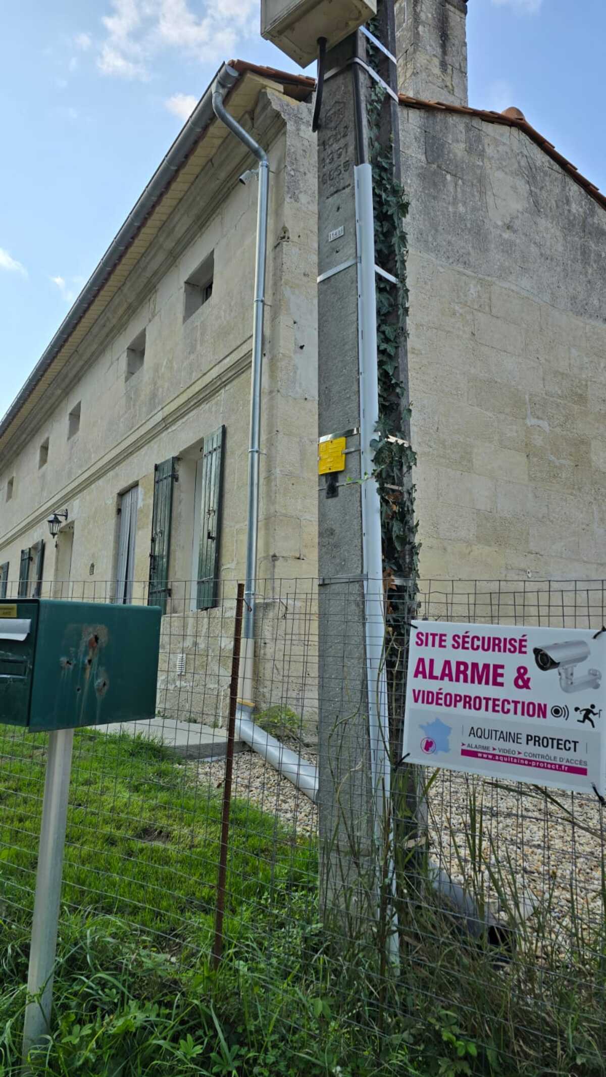 Installation Caméra Sécurité et Maison Intelligente Technicien installant une caméra de sécurité dôme au plafond tout en gérant le système de maison intelligente avec un smartphone affichant un code de verrouillage.