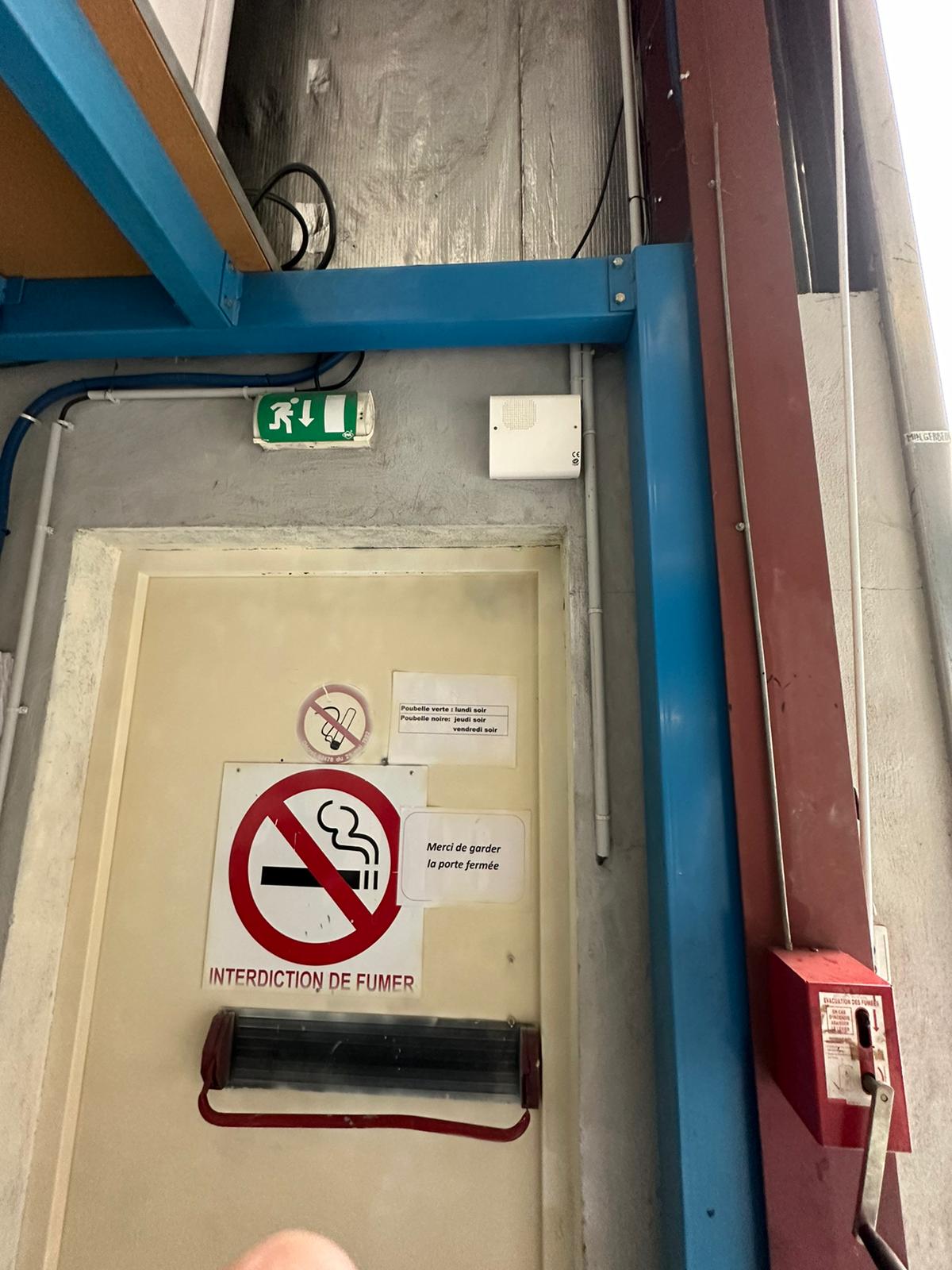 Installation Caméra Sécurité et Maison Intelligente Technicien installant une caméra de sécurité dôme au plafond tout en gérant le système de maison intelligente avec un smartphone affichant un code de verrouillage.